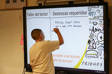 Student writes on a smartboard.