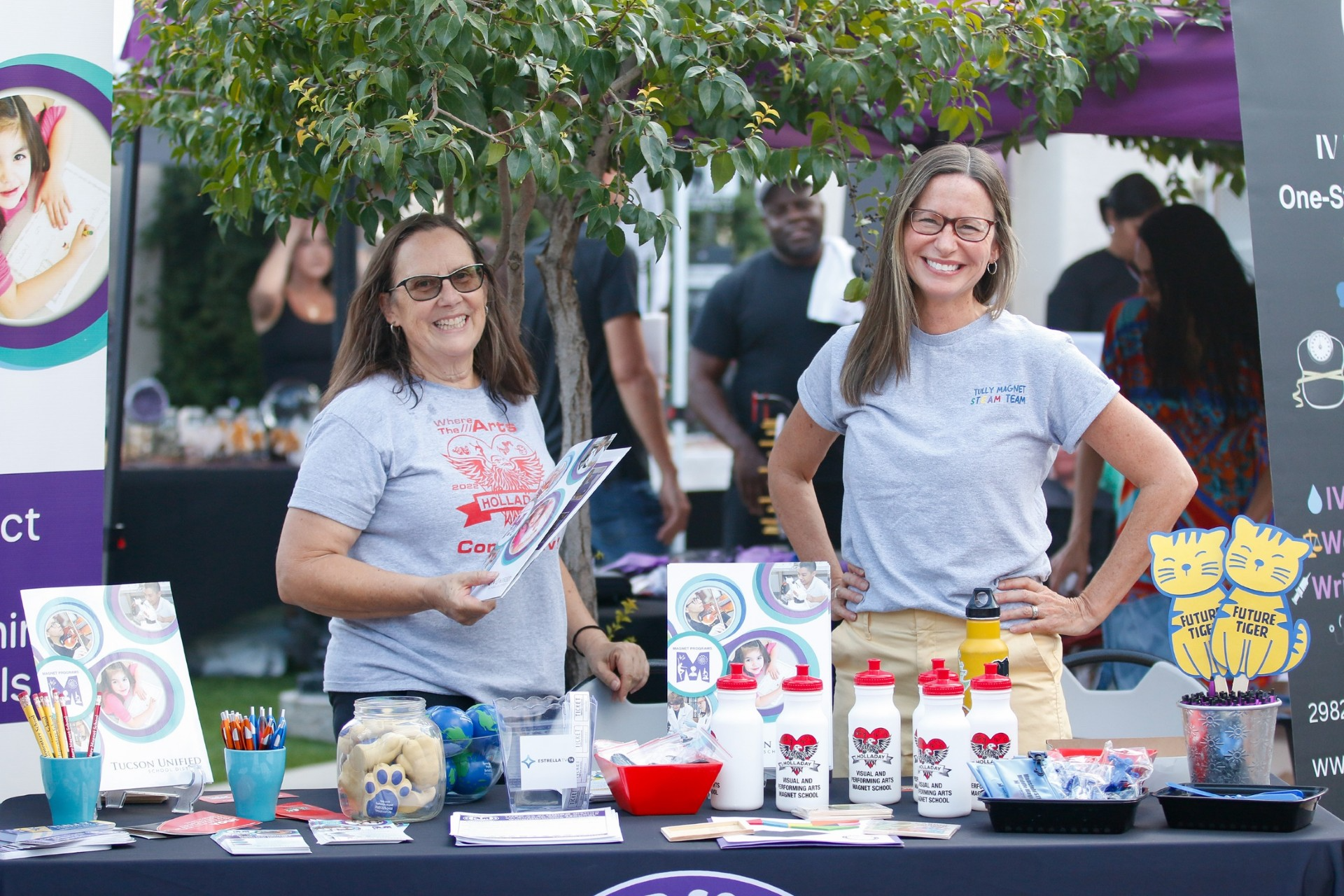 TUSD Magnet Department employees smile at their informational table.