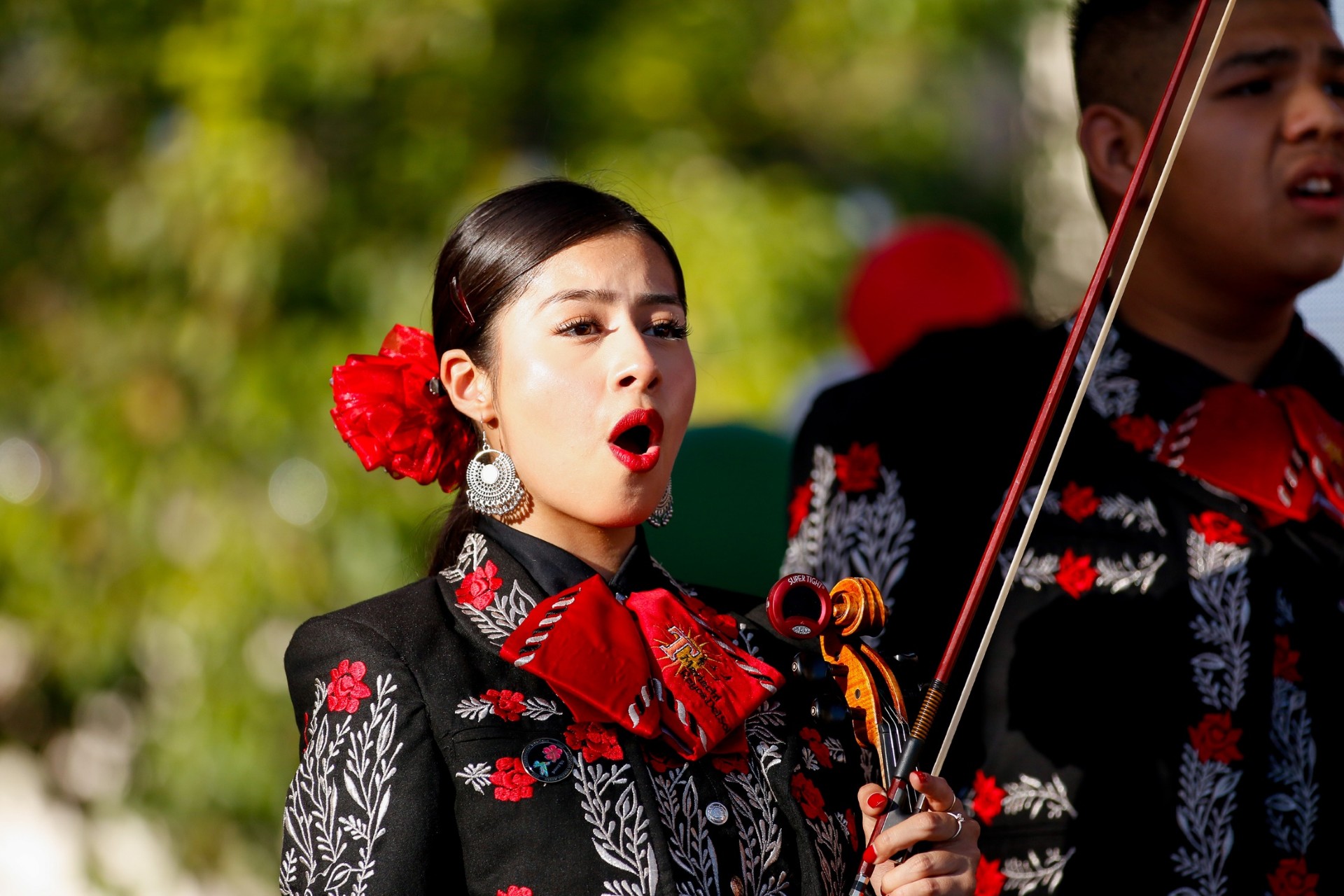 A Tucson High mariachi performer sings and holds her violin