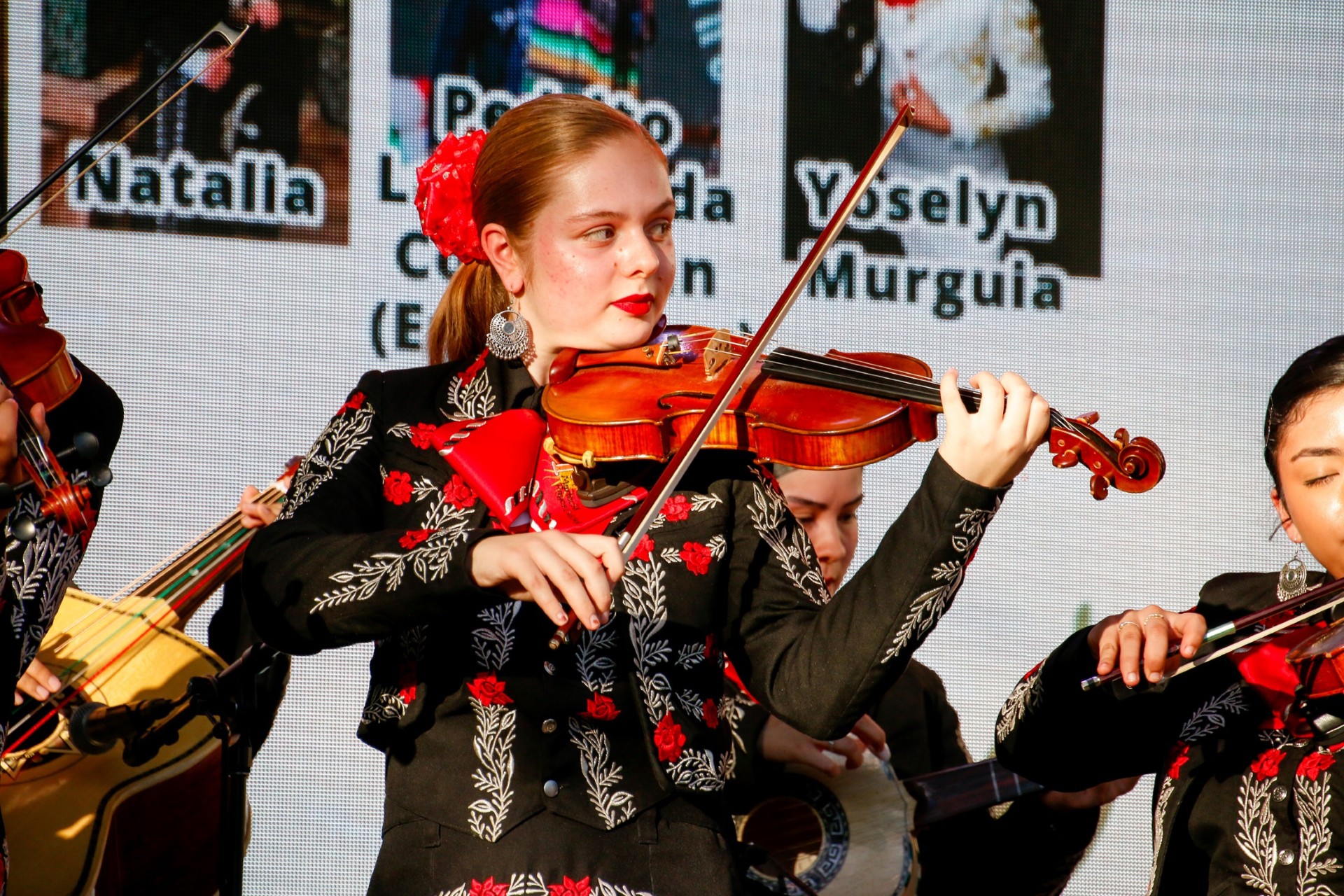 A mariachi performer plays her violin