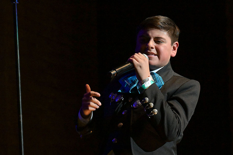 A boy sings into a mic