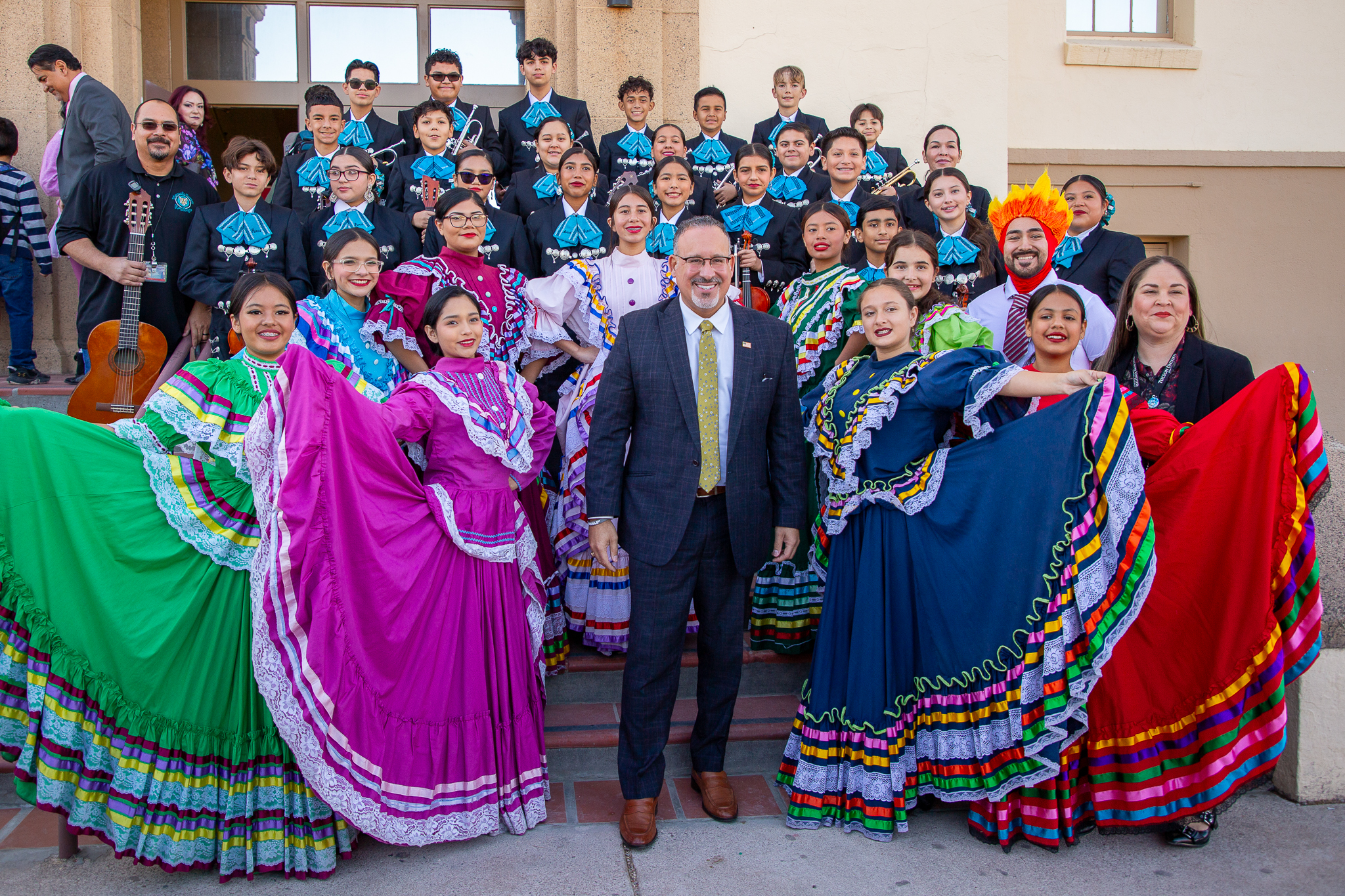 Secretary Cardona poses for a photo with Roskruge's mariachi and folklorico 