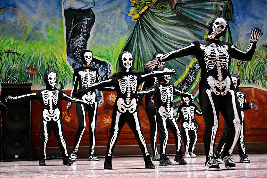 Students dressed as skeletons dance on stage