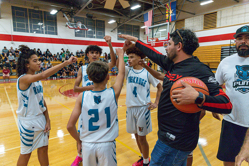 The Roskruge basketball team gives fist bumps during a huddle