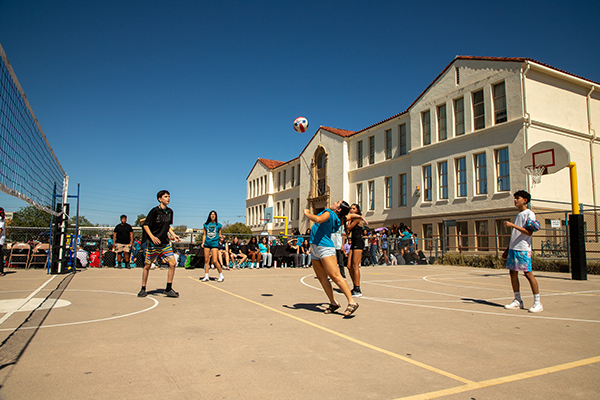 A girl spikes the volleyball over the net