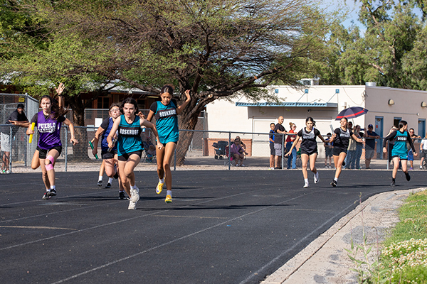 Girls run on the track during the relay race