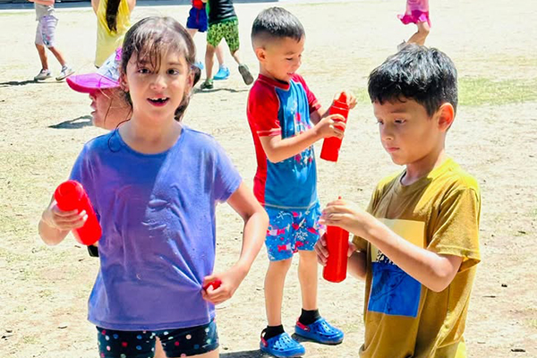 Students smile as they play during water day