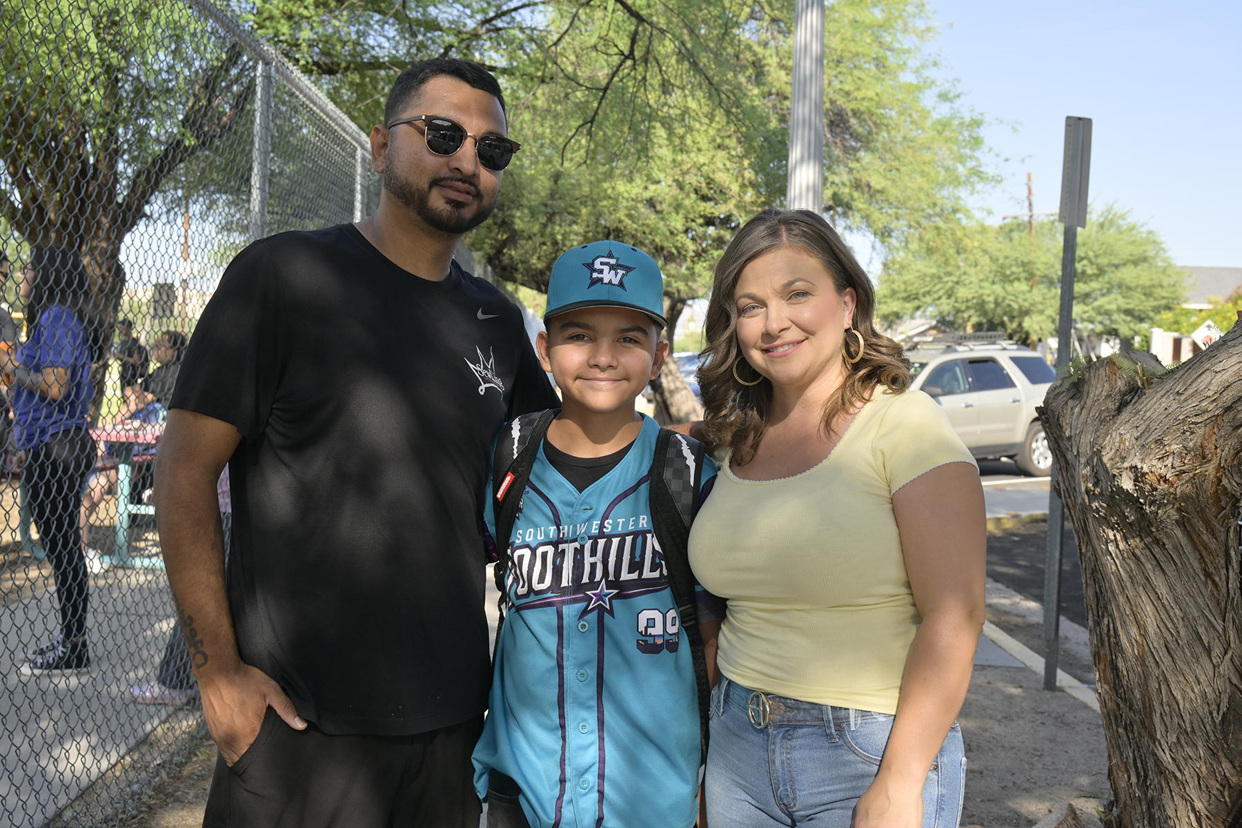 A dad and mom smile with their son on the 2nd day of school