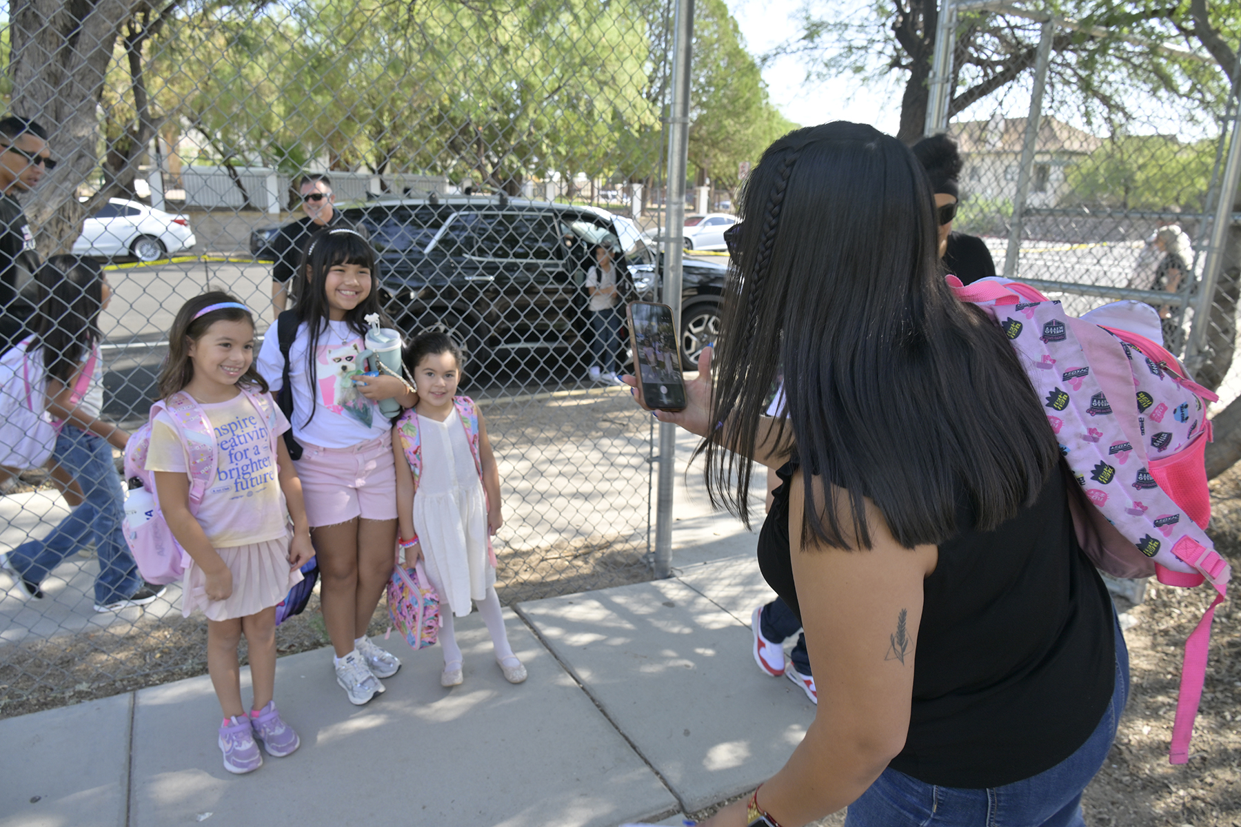 A mom takes a photo of her 3 daughters